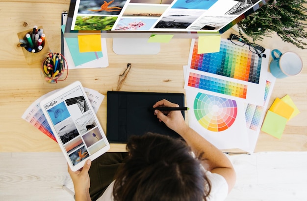 Immagine direttamente sopra di una donna che lavora al computer con campioni di colore