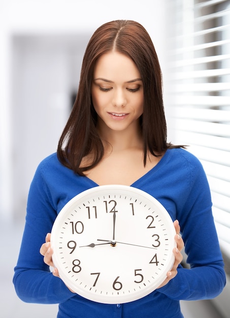 immagine luminosa di una donna che tiene in mano un grande orologio