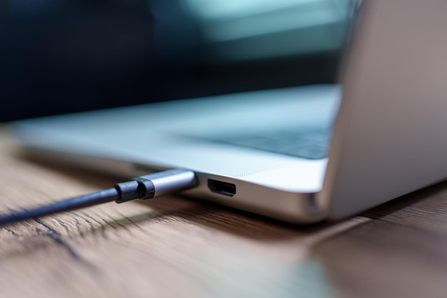 Immagine macro del primo piano Ricarica del computer portatile della batteria con la spina di alimentazione