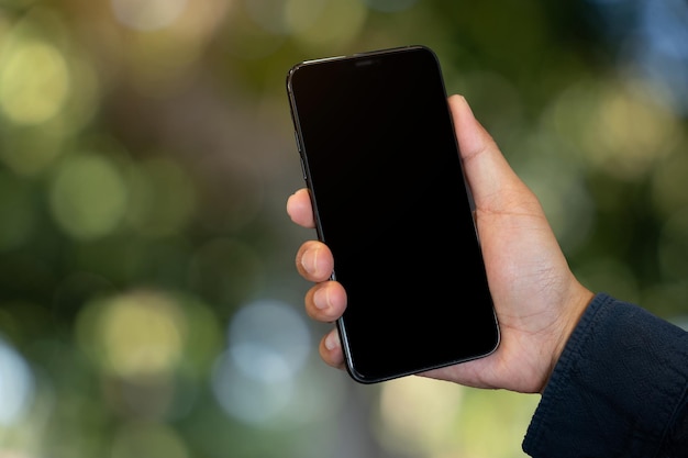 Immagine mockup della mano che tiene il telefono cellulare con sfondo bianco bianco verde natura