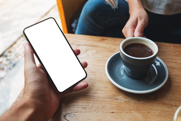 Immagine mockup di un uomo che tiene e mostra il telefono cellulare con lo schermo del desktop nero vuoto agli altri