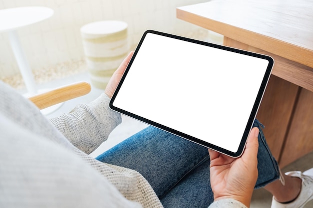 Immagine mockup di una donna che tiene in mano un tablet pc nero con uno schermo desktop bianco vuoto