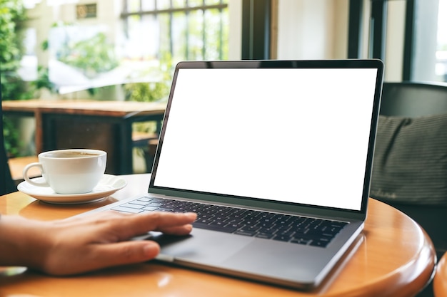 Immagine mockup di una donna che usa e tocca il touchpad del laptop con uno schermo desktop bianco vuoto