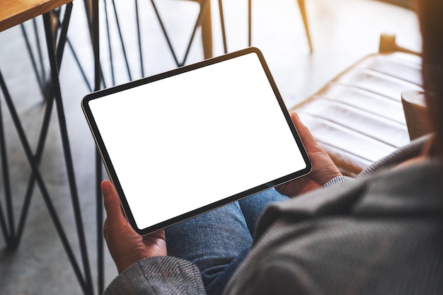 Immagine mockup di una donna in possesso di tablet digitale con schermo desktop bianco vuoto