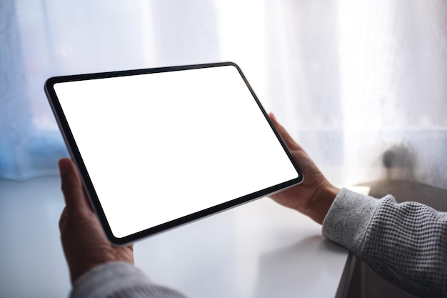 Immagine mockup di una donna in possesso di tablet digitale con schermo desktop bianco vuoto