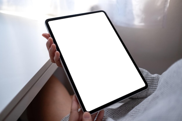 Immagine mockup di una donna in possesso di tablet digitale con schermo desktop bianco vuoto