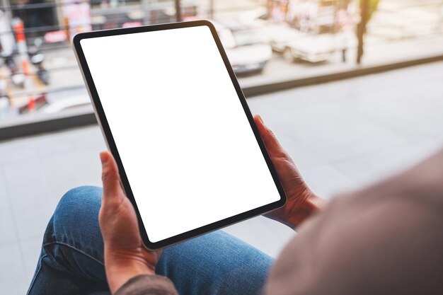 Immagine mockup di una donna in possesso di tablet digitale con schermo desktop bianco vuoto