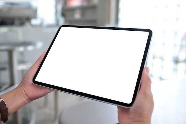 Immagine mockup di una donna in possesso di tablet digitale con schermo desktop bianco vuoto