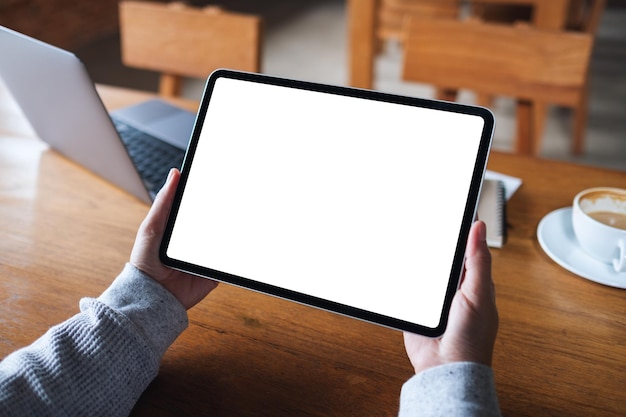 Immagine mockup di una donna in possesso di tablet digitale con schermo desktop bianco vuoto