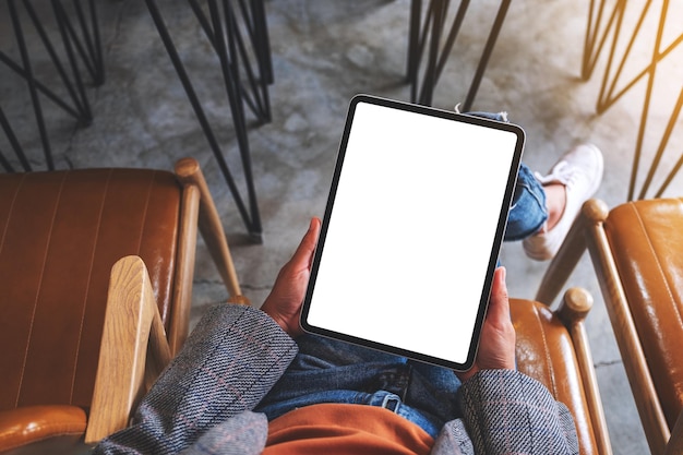 Immagine mockup vista dall'alto di una donna in possesso di tablet digitale con schermo desktop bianco vuoto