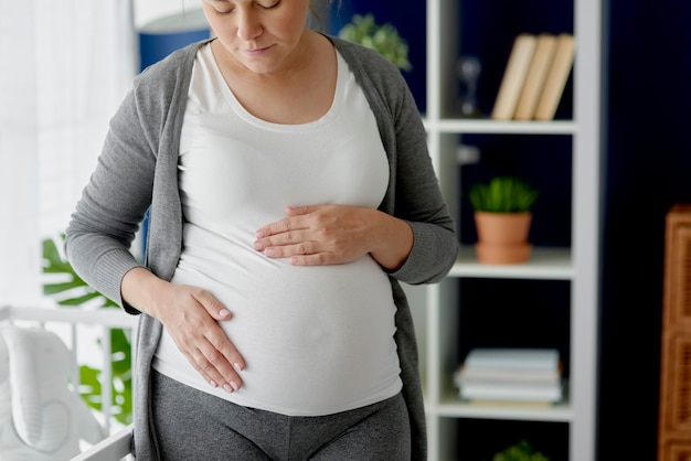 Immagine orizzontale di una donna incinta che si accarezza l'addome