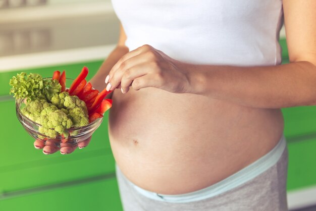 Immagine potata di bella donna incinta che tiene una ciotola.