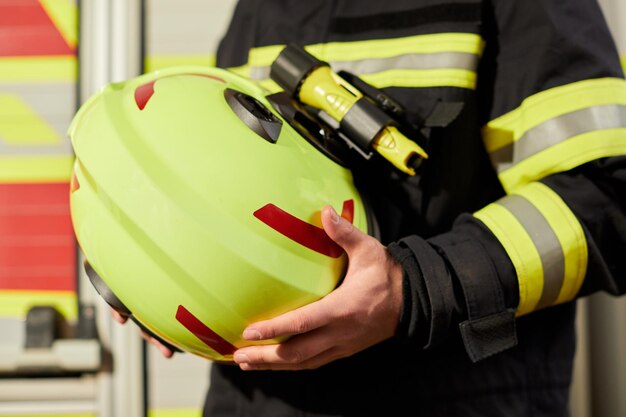 Immagine ravvicinata del casco di un vigile del fuoco Vigile del fuoco in possesso di un casco giallo