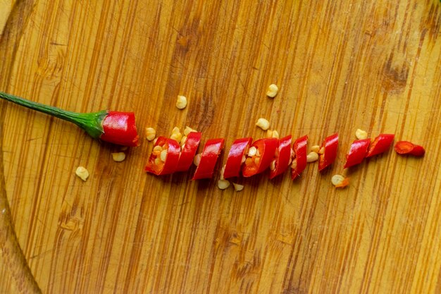 Immagine ravvicinata di peperoncino rosso caldo e semi su tavole di legno