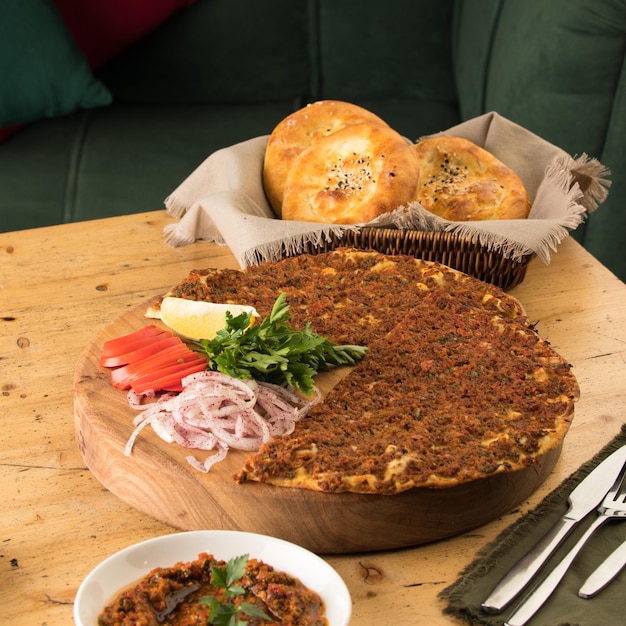 Immagine ravvicinata di un lahmacun e un'insalata vicino al cesto di pane