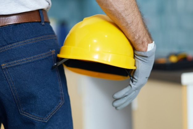 Immagine ravvicinata di un riparatore professionista che tiene un casco in piedi al chiuso