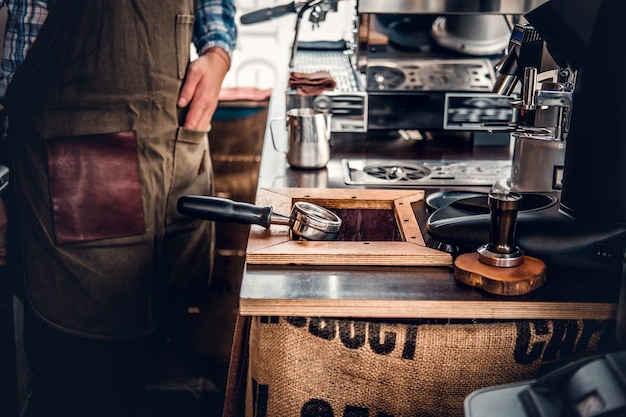 Immagine ravvicinata di un uomo che prepara il cappuccino in una macchina da caffè.