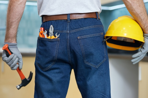 Immagine ravvicinata di vari utensili idraulici manuali in mans jeans tasca posteriore riparatore professionista