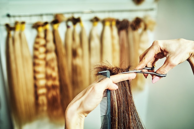 Immagine ritagliata del parrucchiere che taglia le punte dei capelli biondi