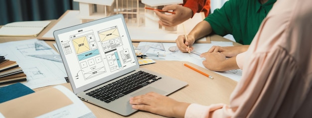 Immagine ritagliata del team di interior designer che discute il colore del materiale mentre il portatile visualizza il sito web wireframe design per cellulari app e sito web Design creativo e concetto di business Variegato