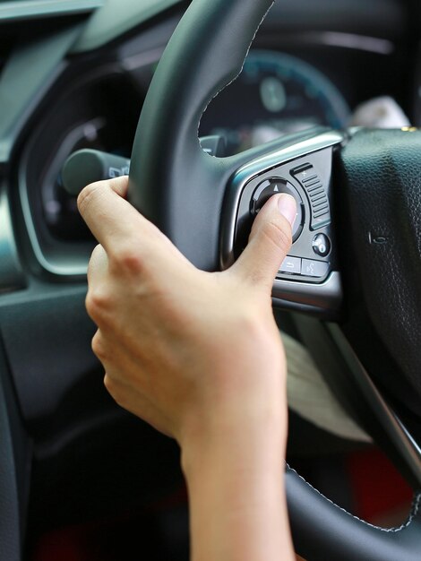 Immagine ritagliata della mano di una persona che usa il telefono cellulare in auto