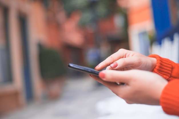 Immagine ritagliata delle mani della donna che tiene il telefono cellulare con lo schermo dello spazio vuoto copia