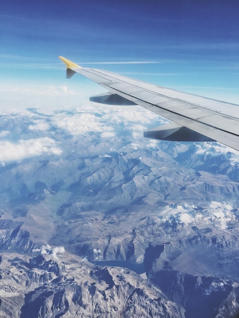 Immagine ritagliata di un aereo che vola sopra un paesaggio