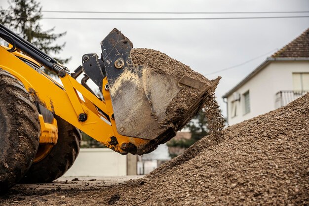 Immagine ritagliata di un bulldozer che preleva ghiaia nell'area di costruzione