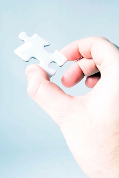 Immagine ritagliata di un pezzo di puzzle in mano