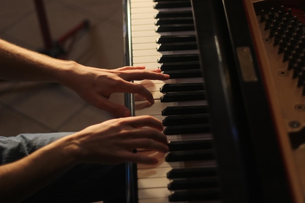 Immagine ritagliata di un uomo che suona il pianoforte a coda durante il tramonto