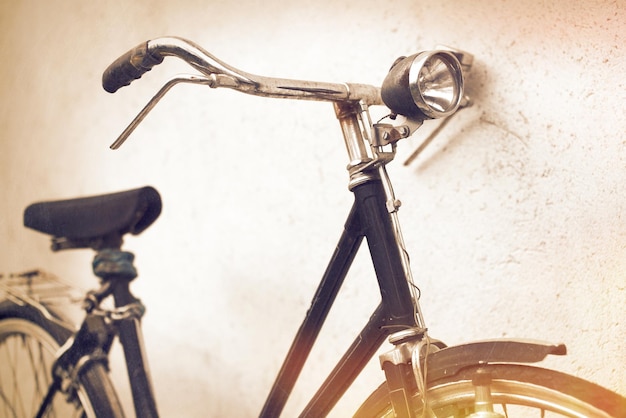 Immagine ritagliata di una bicicletta con il faro appoggiato al muro