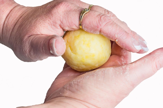 Immagine ritagliata di una donna che fa gnocchi di patate su uno sfondo bianco