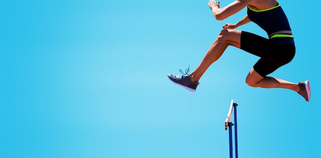 Immagine ritagliata di una donna che pratica salto ostacoli su sfondo blu