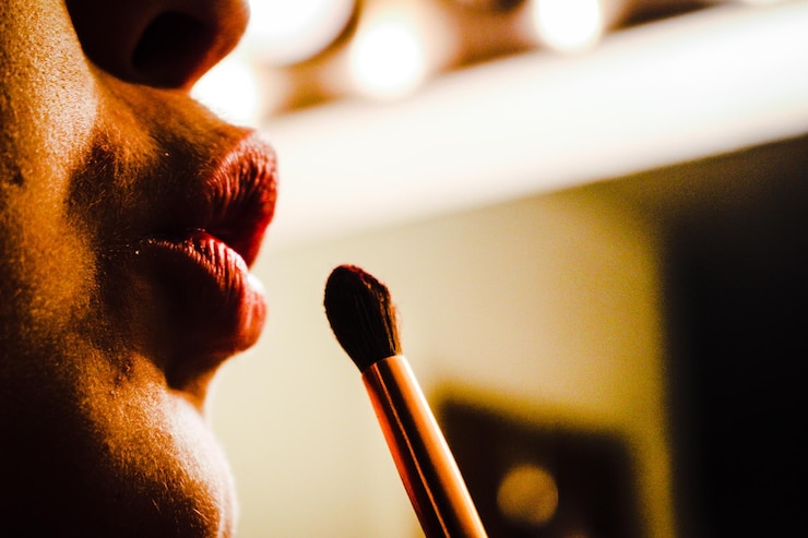 Foto immagine ritagliata di una donna che si applica il rossetto