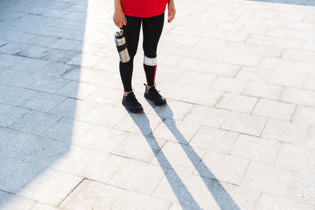 Immagine ritagliata di una giovane donna sportiva facendo esercizi di stretching all'aperto