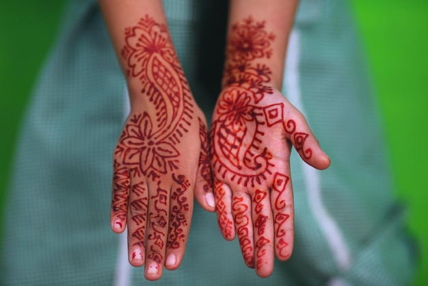 Immagine ritagliata di una persona che mostra una mano tatuata di henna