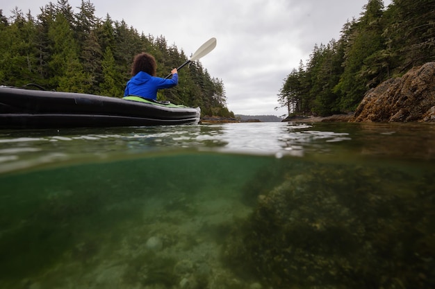 Immagine sopra e sotto di una donna avventurosa che fa kayak nell'Oceano Pacifico