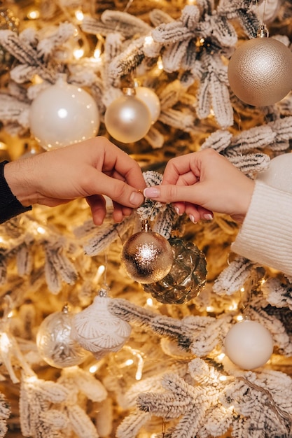 Immagine verticale bella giovane coppia romantica che decora l'albero di Natale