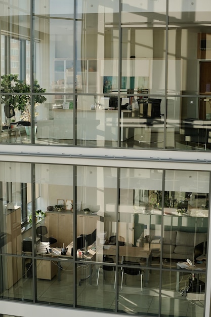 Immagine verticale di un moderno edificio per uffici con pareti in vetro e posti di lavoro per uomini d'affari all'interno