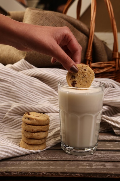 Immergere deliziosi biscotti in un bicchiere di latte