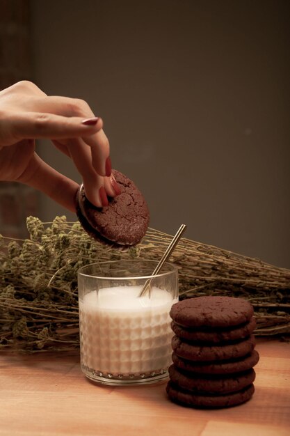 Immergere deliziosi biscotti in un bicchiere di latte