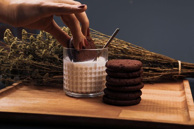 Immergere deliziosi biscotti in un bicchiere di latte