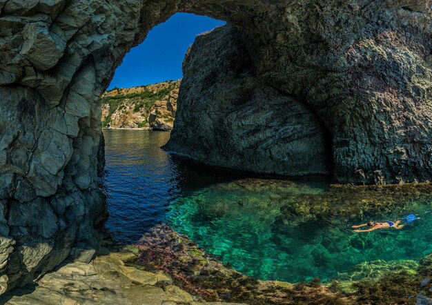 Immersione della ragazza nella grotta di dianas sebastopoli fiolent crimea su uno sfondo di coste rocciose il concetto