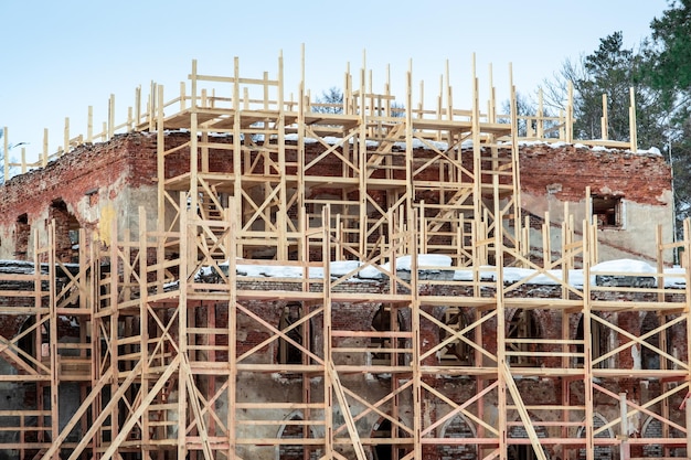 Impalcature intorno all'edificio in mattoni rossi Restauro della casa dopo la distruzione globale