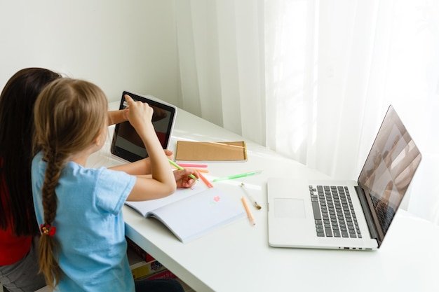 Imparare da casa, concetto di bambino della scuola domestica. I bambini piccoli studiano l'apprendimento online da casa con il laptop. Quarantena e concetto di distanza sociale.