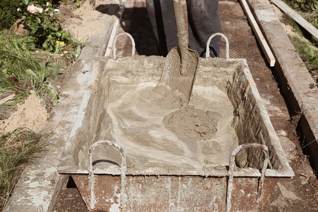 Impastare il cemento per versare il percorso del giardino, lavori di costruzione del giardino.