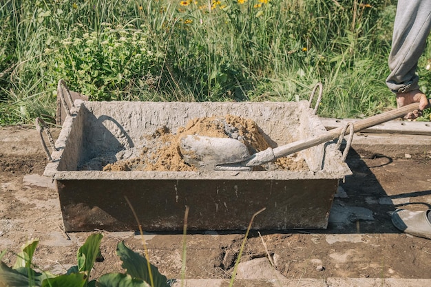 Impastare il cemento per versare il percorso del giardino, lavori di costruzione del giardino.