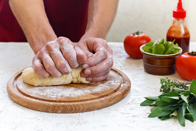 Impasto. Il processo di produzione della pizza. Ingredienti per la pizza Impastare la pasta con le mani