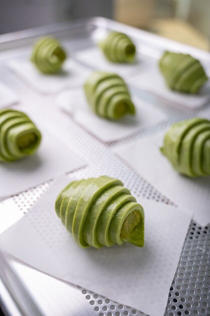 Impasto per croissant al tè verde crudo con ripieno di tè verde prima della cottura sul vassoio.