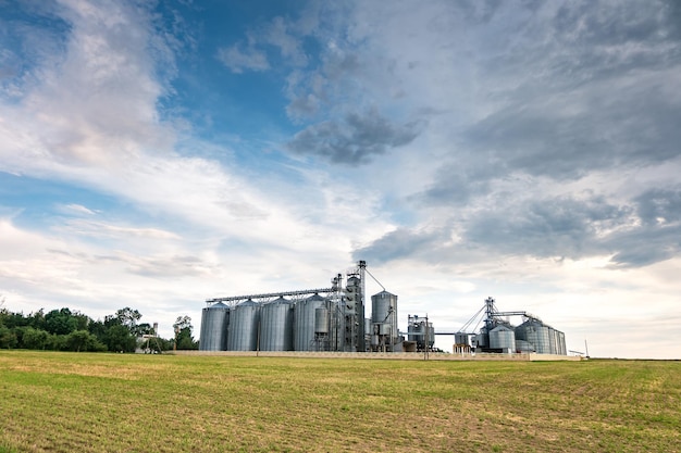 Impianto di agrotrasformazione per la lavorazione e silos per asciugatura pulitura e stoccaggio di prodotti agricoli farina cereali e grano con belle nuvole